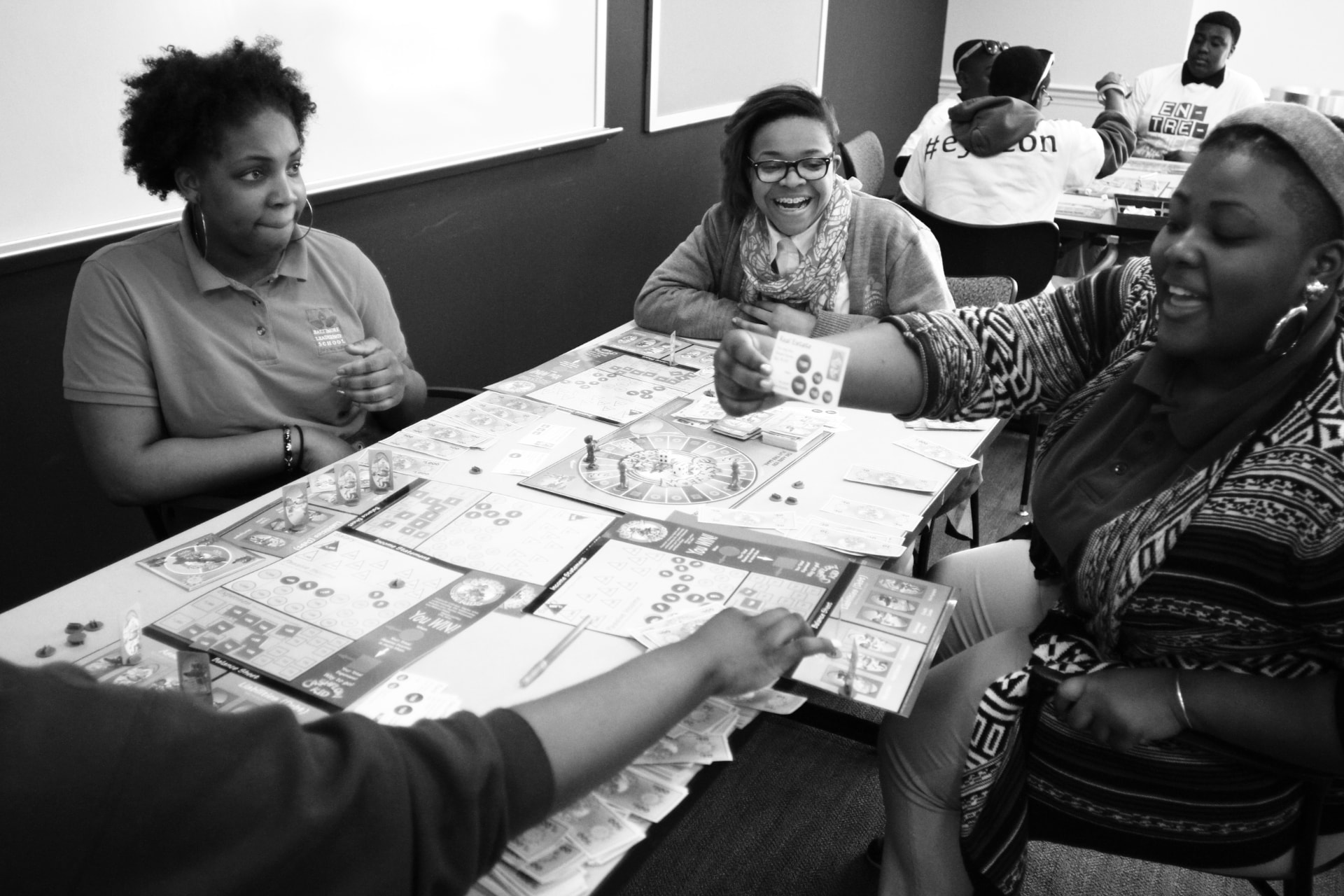 Students gathered around a table playing a financial literacy board game together